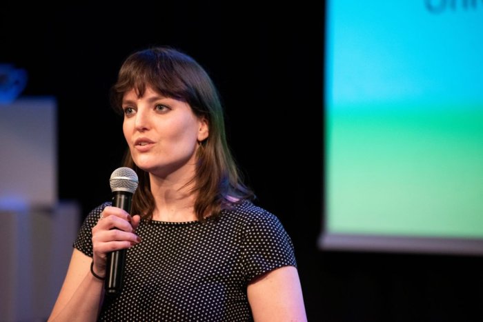 Foto van Kila van der Starre op podium met microfoon